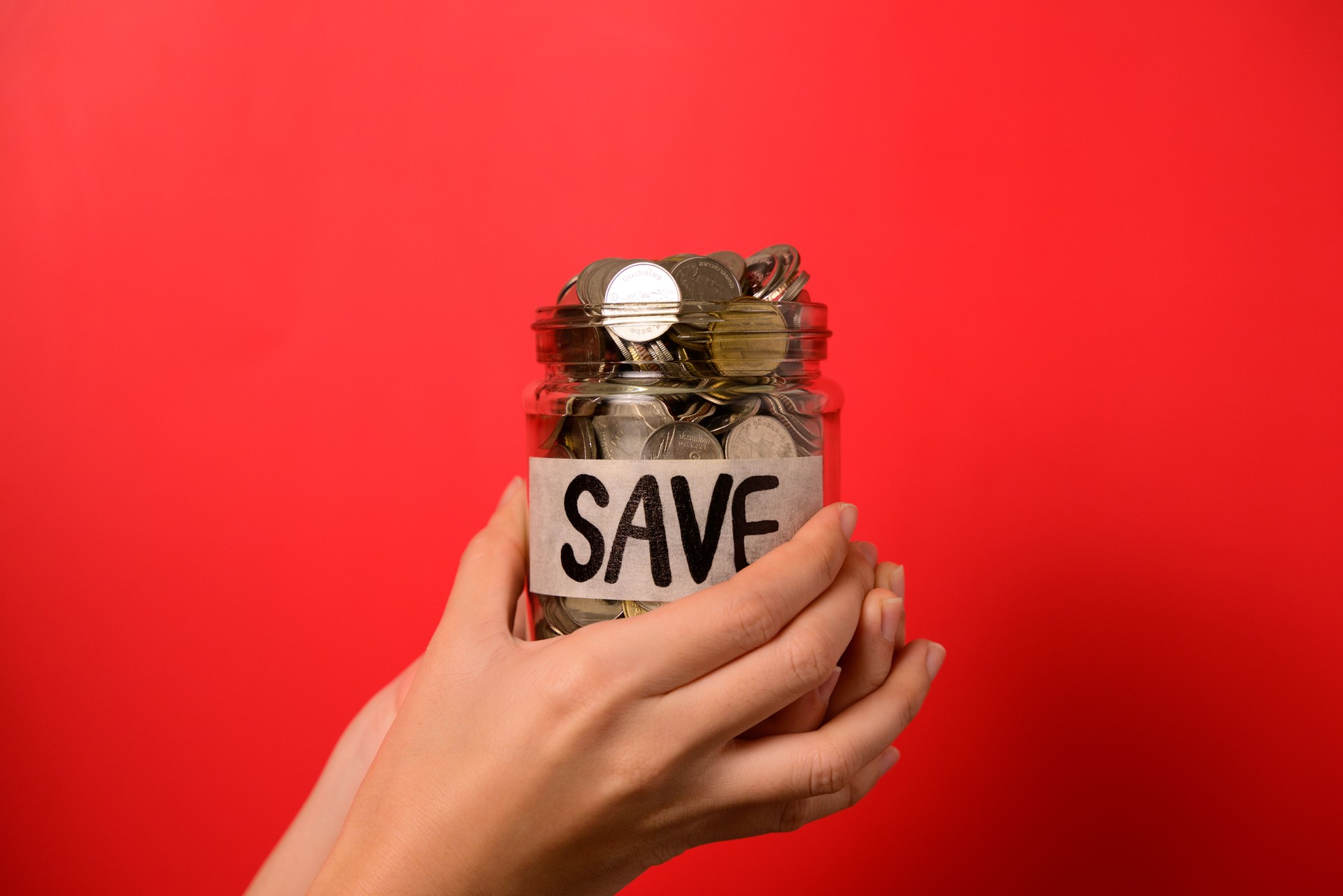 Hand holding coins in glass jar, Financial business investment, Growing money, People saving money, Money for future, Money saving concept